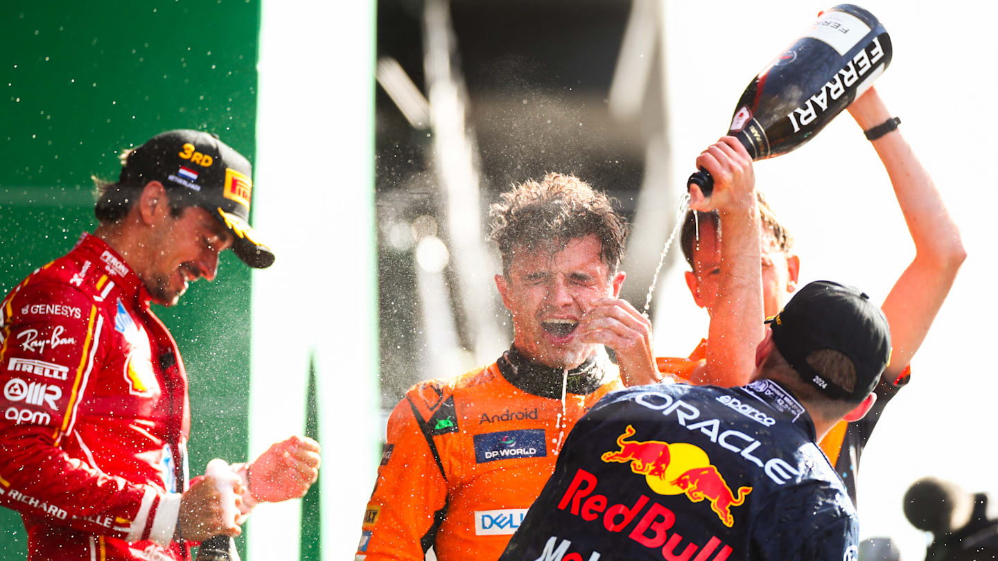 ZANDVOORT, NETHERLANDS - AUGUST 25: Lando Norris of McLaren and Great Britain celebrates finishing in first position with Max Verstappen of Oracle Red Bull Racing and The Netherlands  and Charles Leclerc of Ferrari and Monaco during the F1 Grand Prix of Netherlands at Circuit Zandvoort on August 25, 2024 in Zandvoort, Netherlands. (Photo by Peter Fox - Formula 1/Formula 1 via Getty Images)