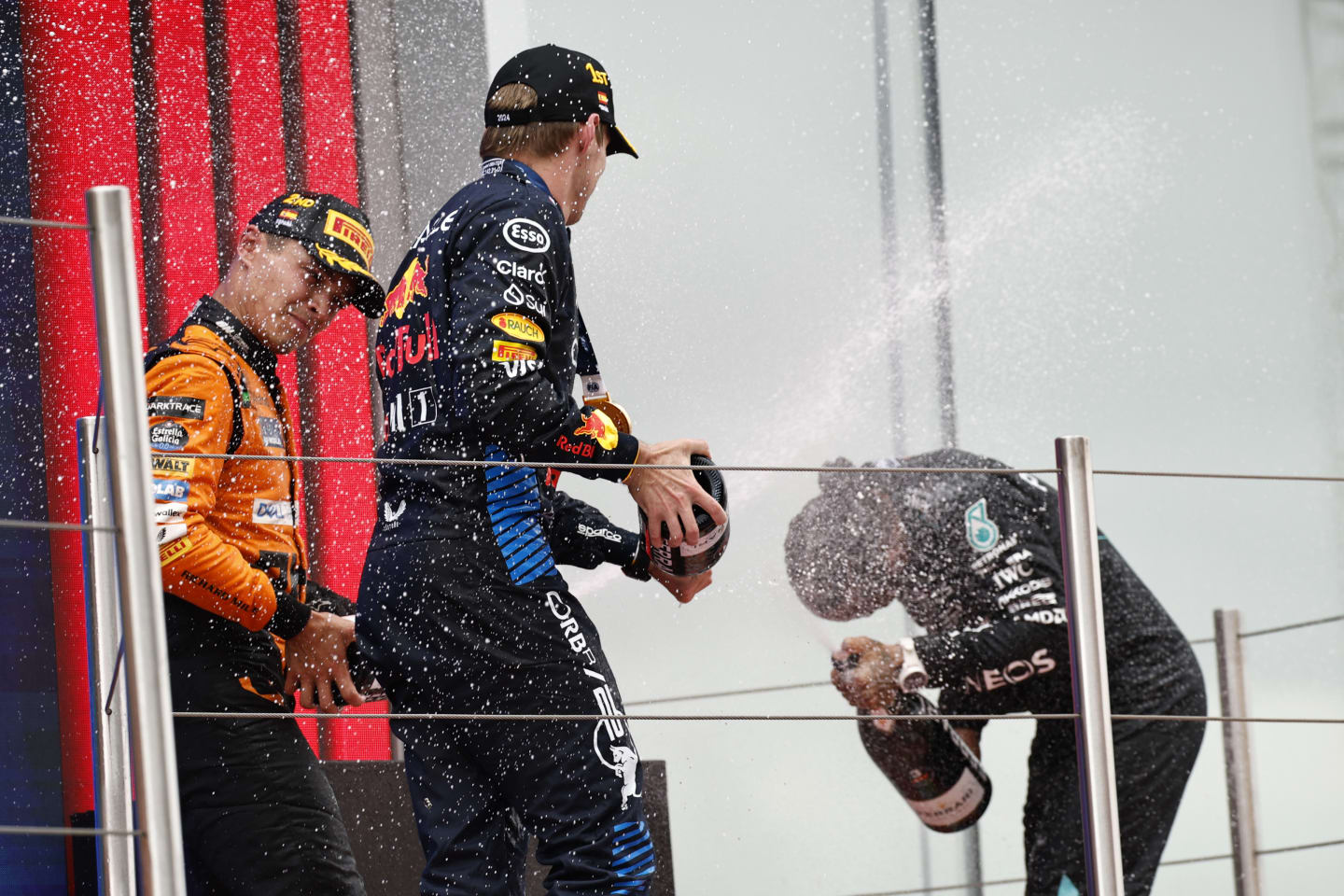 BARCELONA, SPAIN - JUNE 23: Race winner Max Verstappen of the Netherlands and Oracle Red Bull Racing, Second placed Lando Norris of Great Britain and McLaren, and Third placed Lewis Hamilton of Great Britain and Mercedes celebrate on the podium during the F1 Grand Prix of Spain at Circuit de Barcelona-Catalunya on June 23, 2024 in Barcelona, Spain. (Photo by Chris Graythen/Getty Images)
