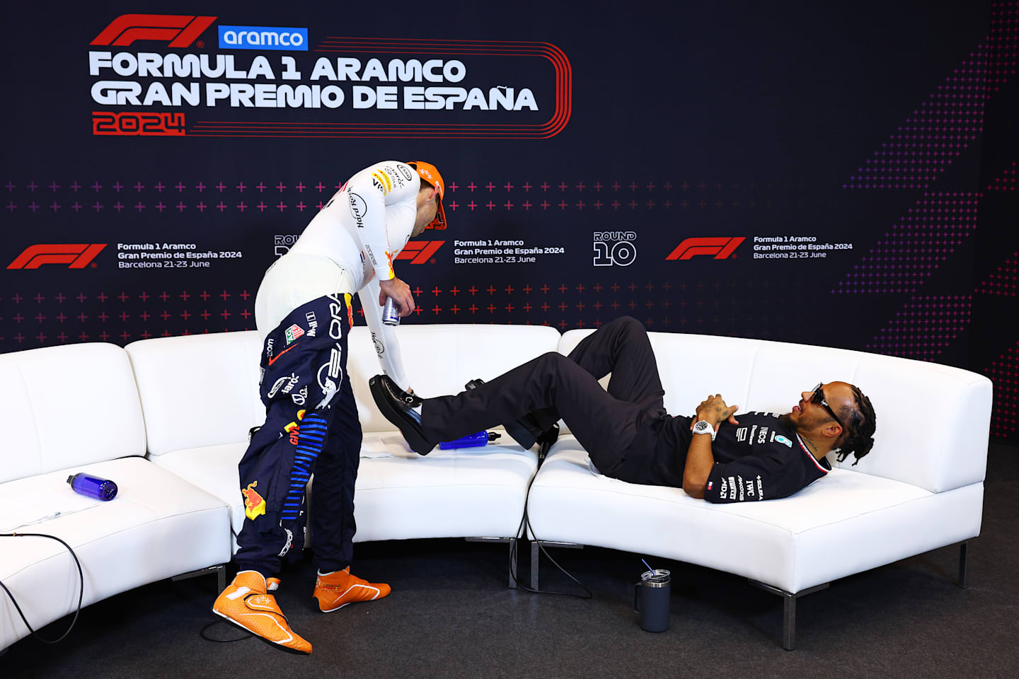 BARCELONA, SPAIN - JUNE 23: Third placed Lewis Hamilton of Great Britain and Mercedes lies on the sofa as he waits for a press conference as Race winner Max Verstappen of Oracle Red Bull Racing takes a seat. (Photo by Clive Rose/Getty Images)