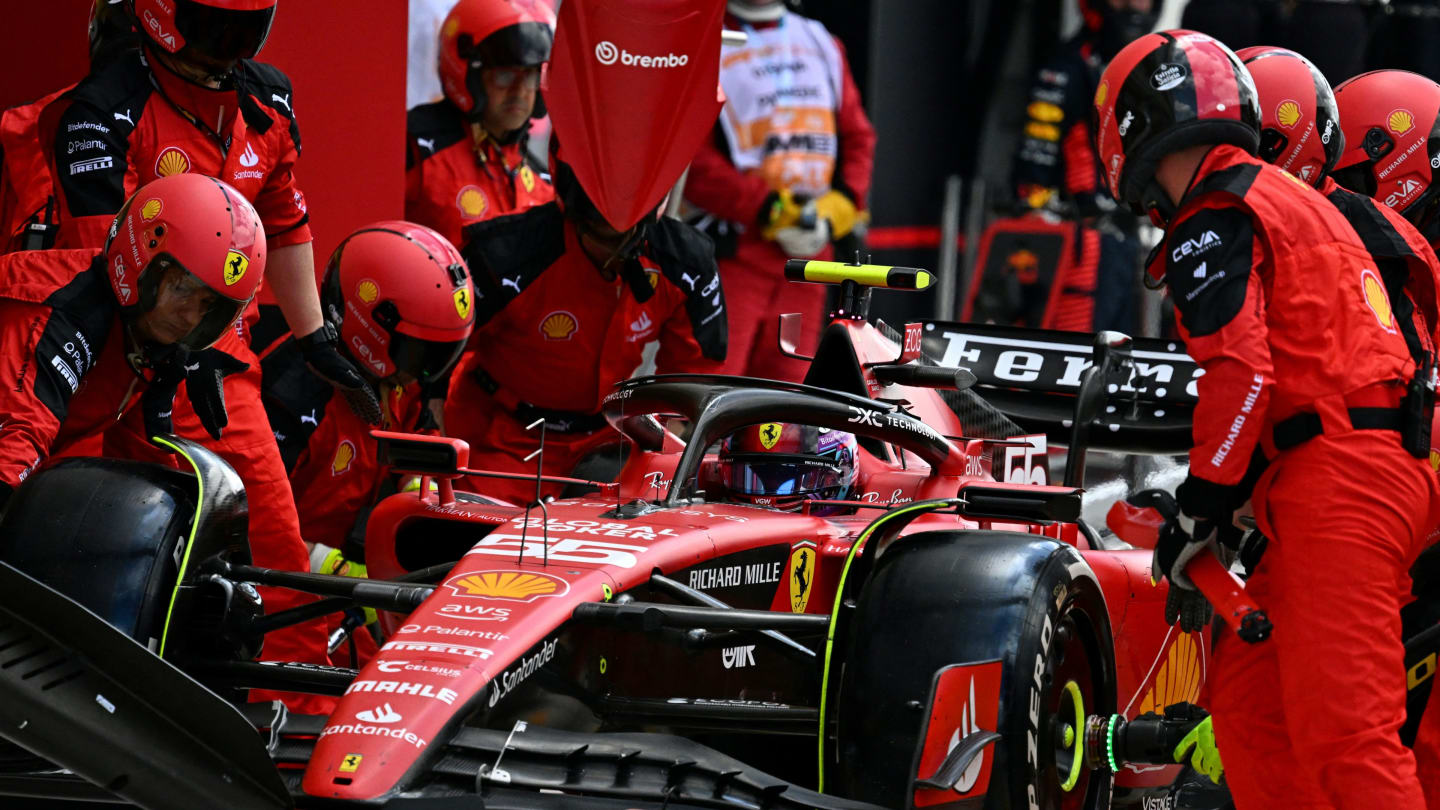 Crew members work on the car of Ferrari's Spanish driver Carlos Sainz Jr. in the pitlane during the