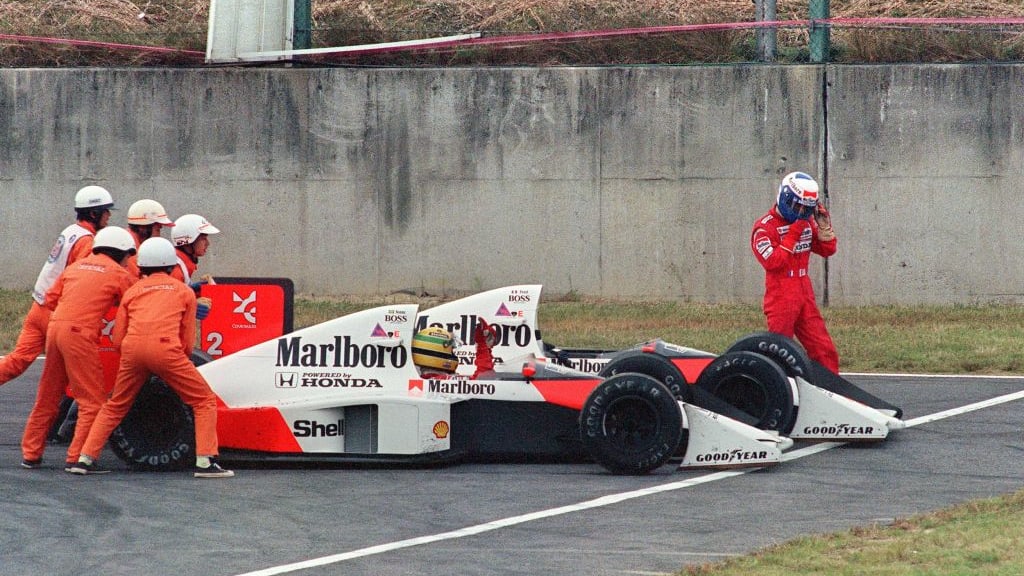 Ayrton Senna of Brazil is given a push from circuit marshals for a restart while his teammate and
