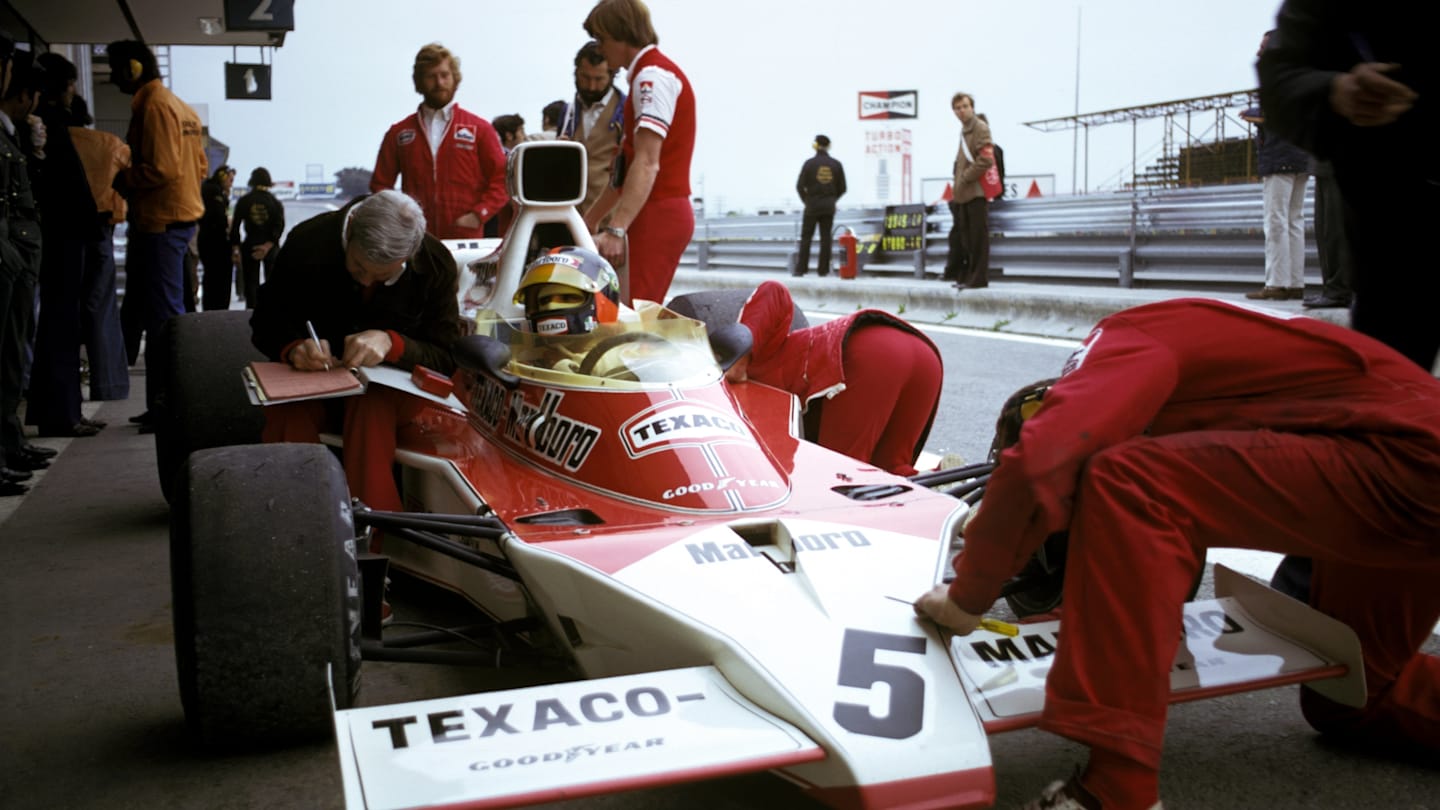 Third placed Emerson Fittipaldi (BRA) has adjustments made to his McLaren M23 whilst giving set-up
