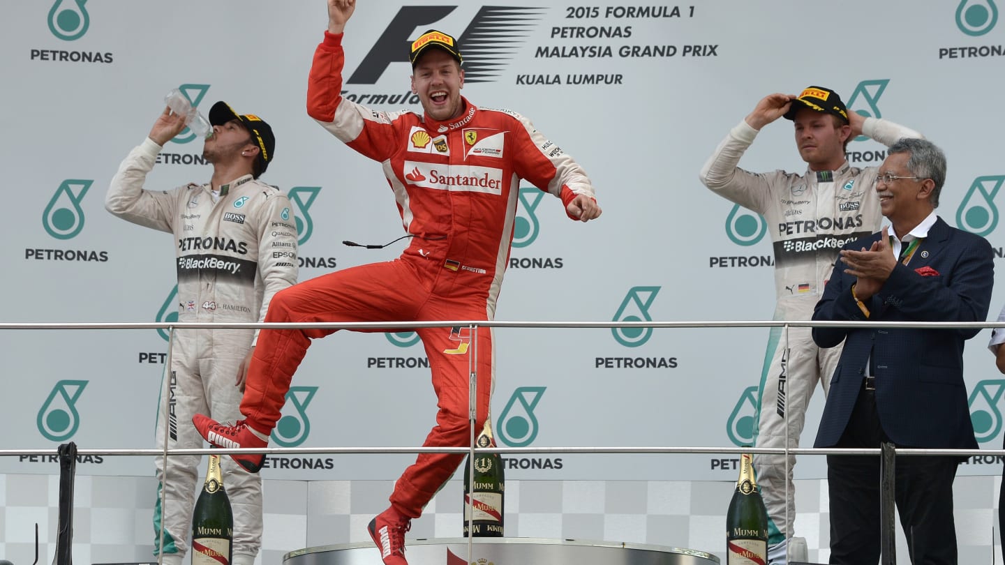 Ferrari's German driver Sebastian Vettel (C) celebrates on the podium in front of second placed