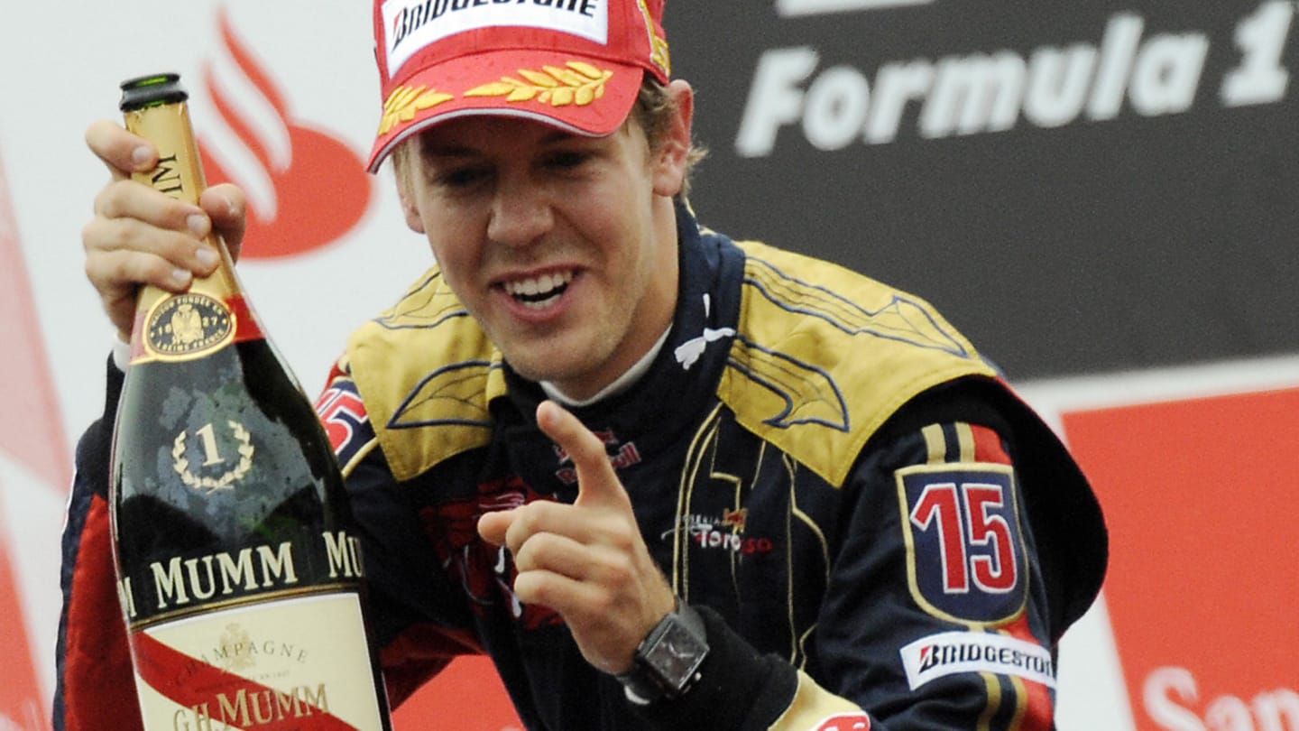Toro Rosso's German driver Sebastien Vettel celebrates on the podium of the Monza racetrack on