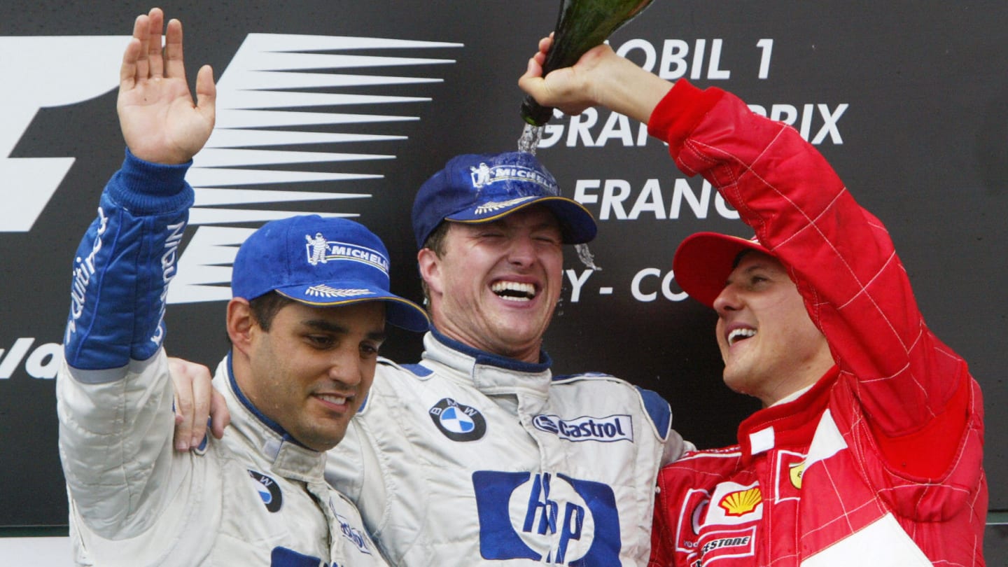 German Ferrari driver Michael Schumacher (R) sprays champagne on his brother BMW-Williams driver