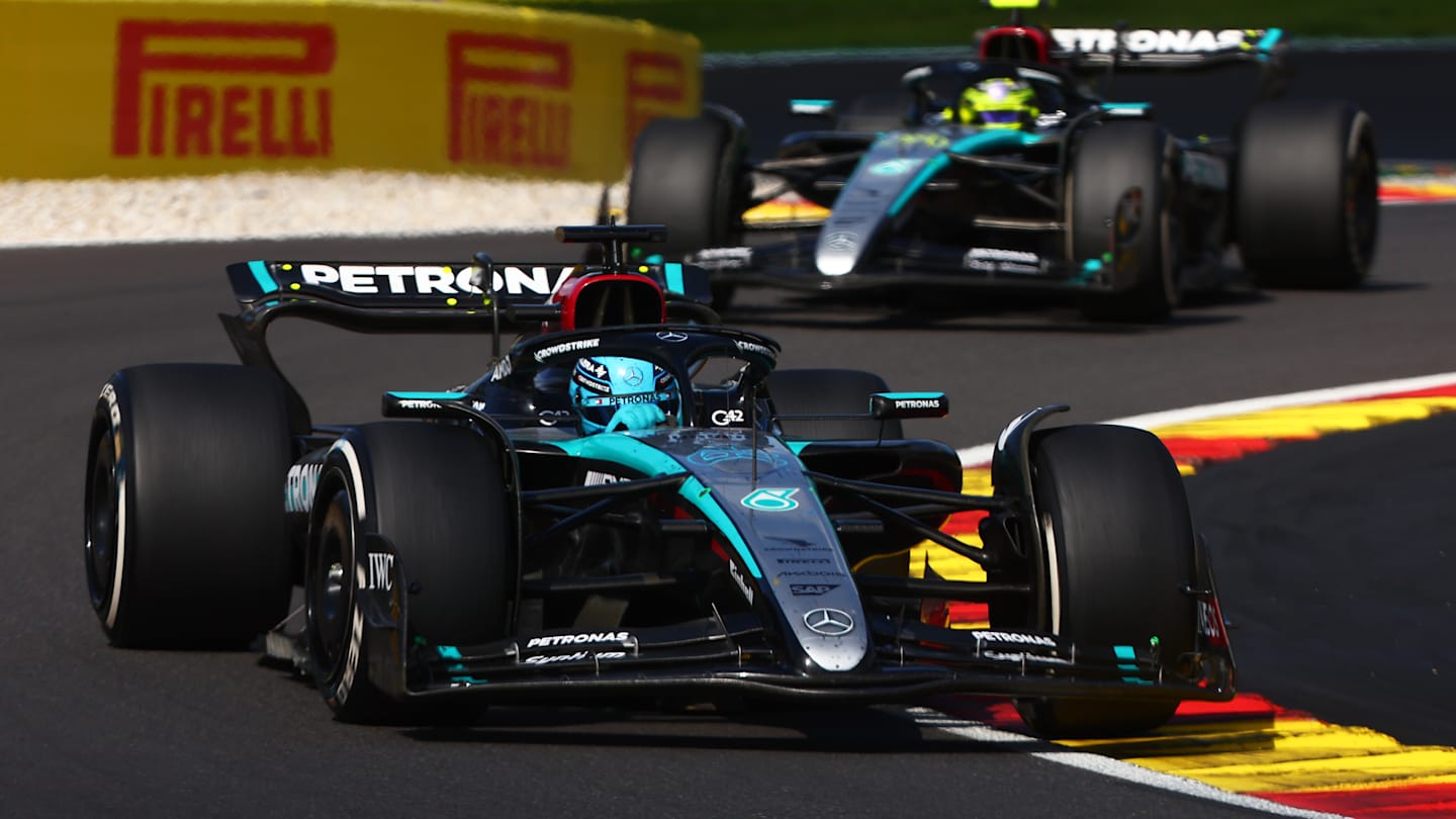 Mercedes' British driver George Russell (C) gestures as he arrives to attend the Drivers Parade