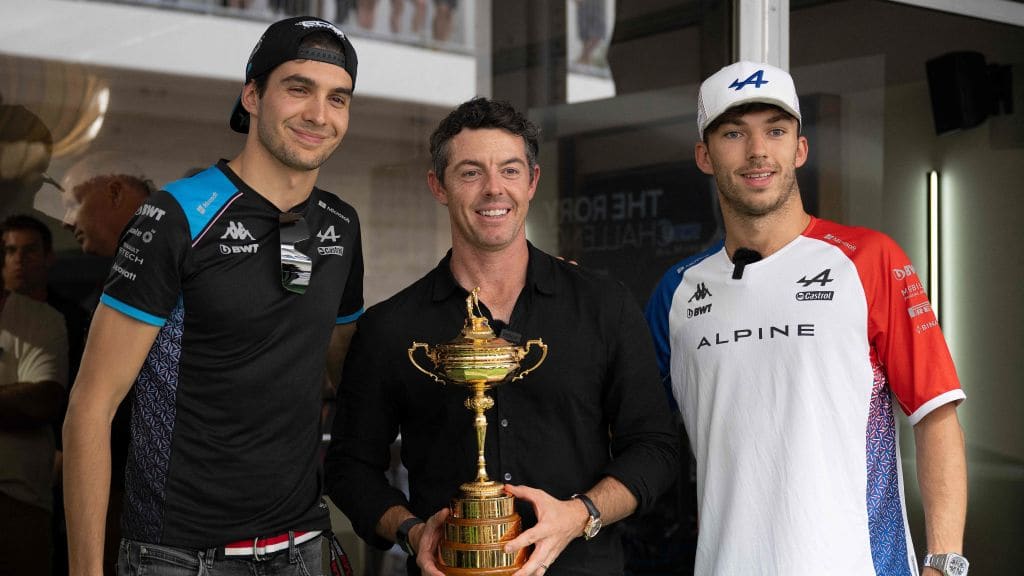 Golfer Rory McIlroy (C), of Northern Ireland, holds the Ryder Cup as he poses with Alpine's French
