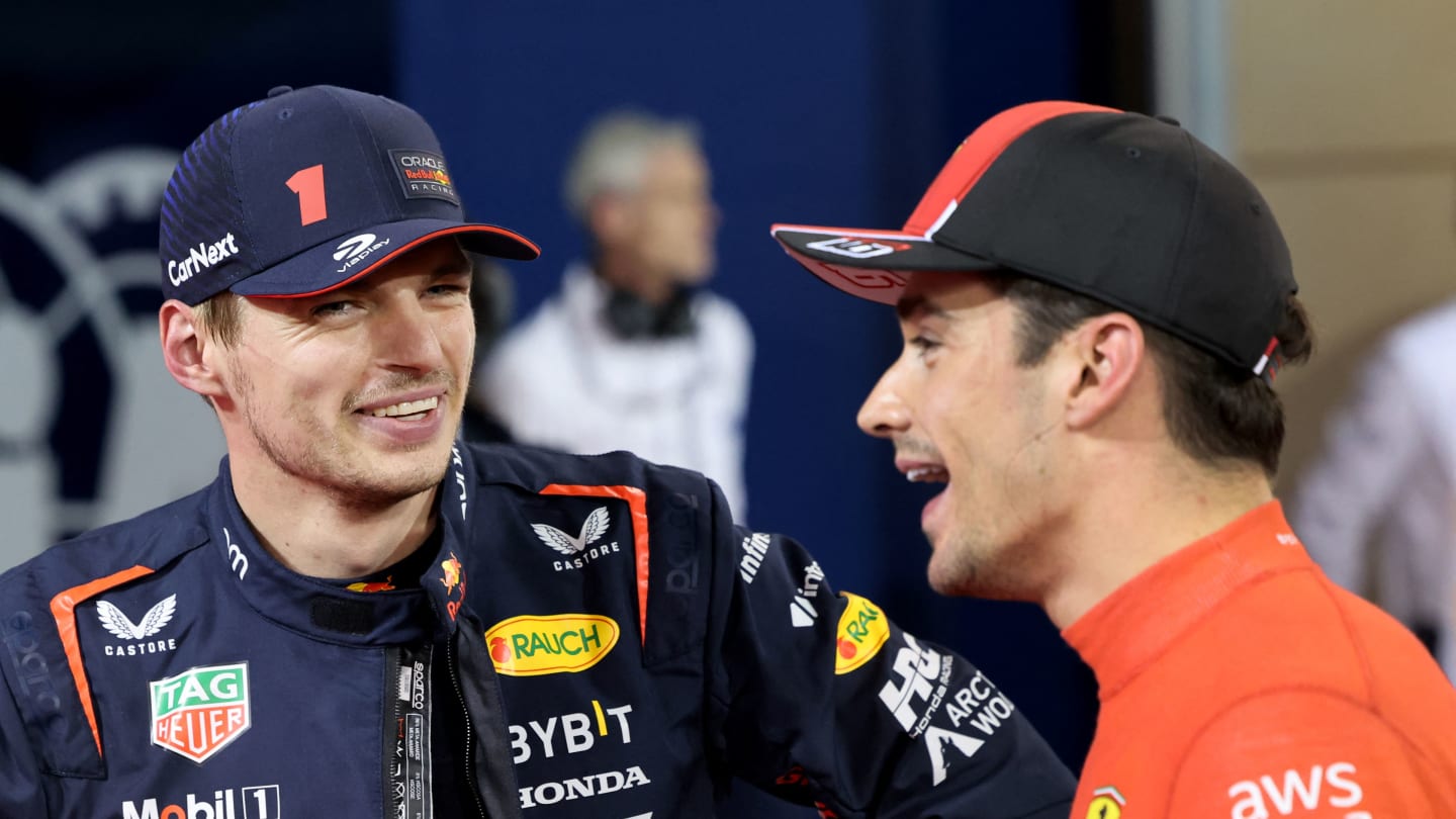 Red Bull Racing's Dutch driver Max Verstappen (L) speaks with Ferrari's Monegasque driver Charles