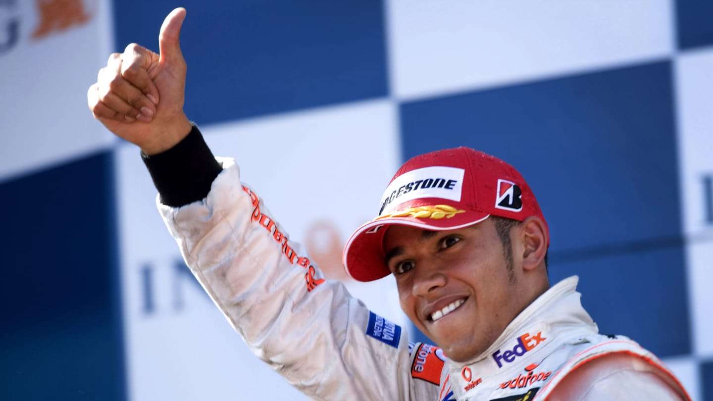 British Formula One driver Lewis Hamilton celebrates on the podium after finishing third in his