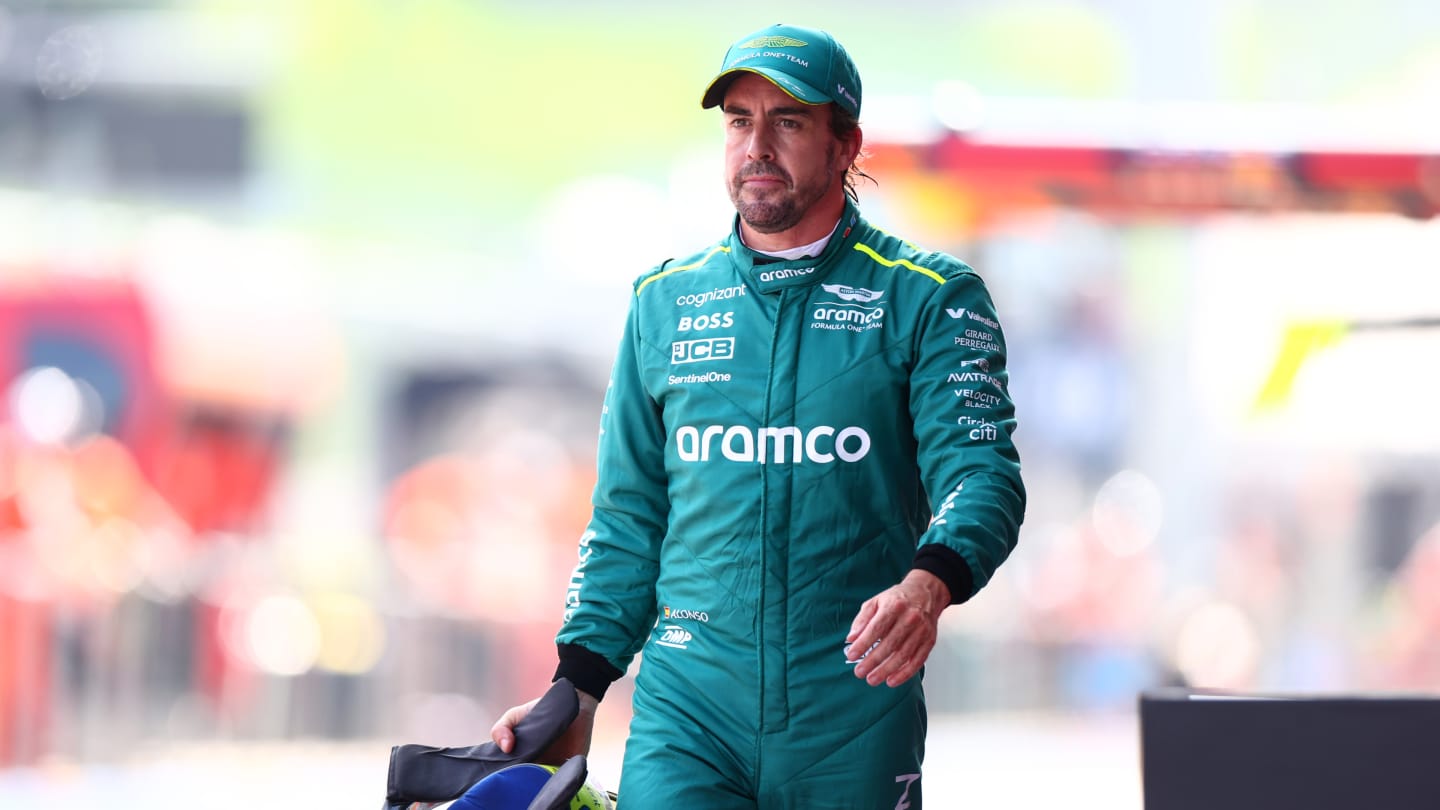 SPIELBERG, AUSTRIA - JUNE 29: 15th placed qualifier Fernando Alonso of Spain and Aston Martin F1 Team walks in the Pitlane during qualifying ahead of the F1 Grand Prix of Austria at Red Bull Ring on June 29, 2024 in Spielberg, Austria. (Photo by Bryn Lennon - Formula 1/Formula 1 via Getty Images)