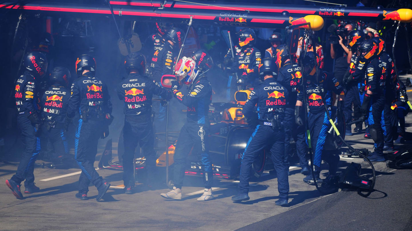 Red Bull Racing's Dutch driver Max Verstappen (C) walks back to the garage after smoke billowing