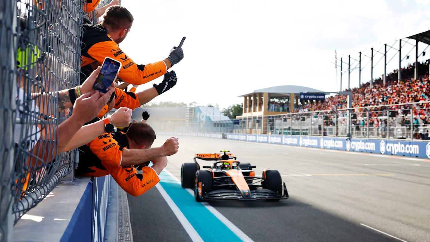 Lando Norris, McLaren MCL38, 1st position, crosses the line to cheers from his team on the pit wall