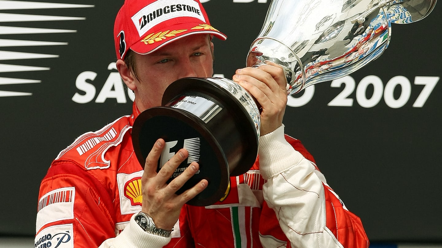 TOPSHOT - Finnish Formula One driver Kimi Raikkonen of Ferrari kisses his trophy during the podium