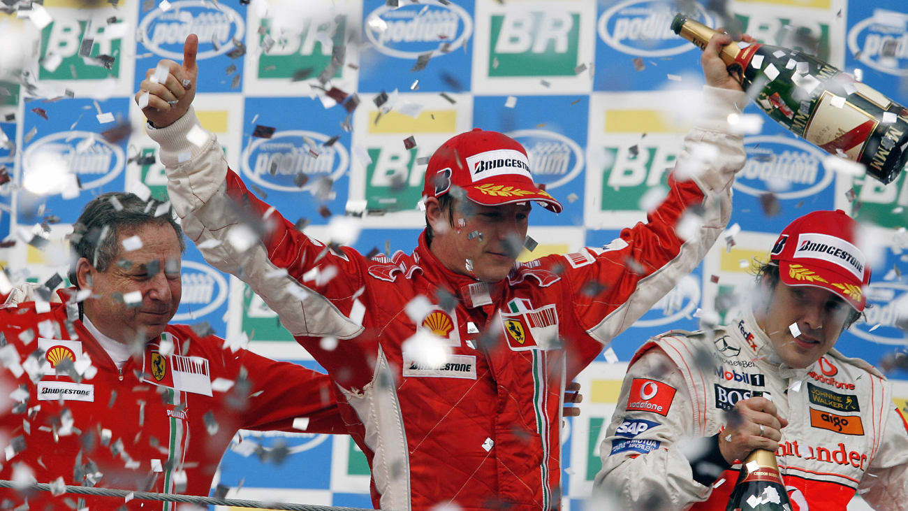 Finnish Formula One driver Kimi Raikkonen (C) celebrates with  Ferrari team mananger Jean Todt (L)