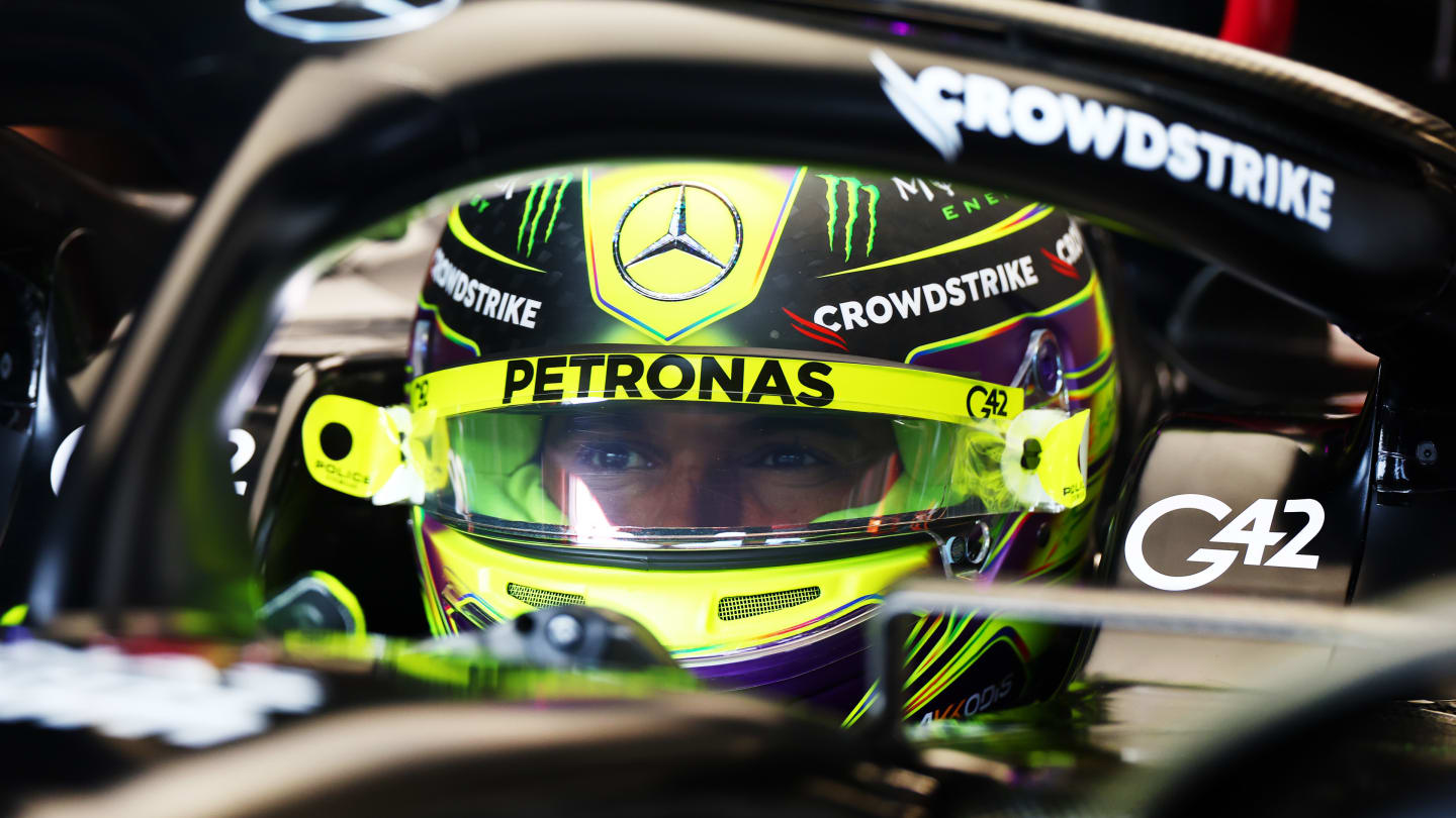 Mercedes' British driver Lewis Hamilton adjusts his gloves during the second practice session