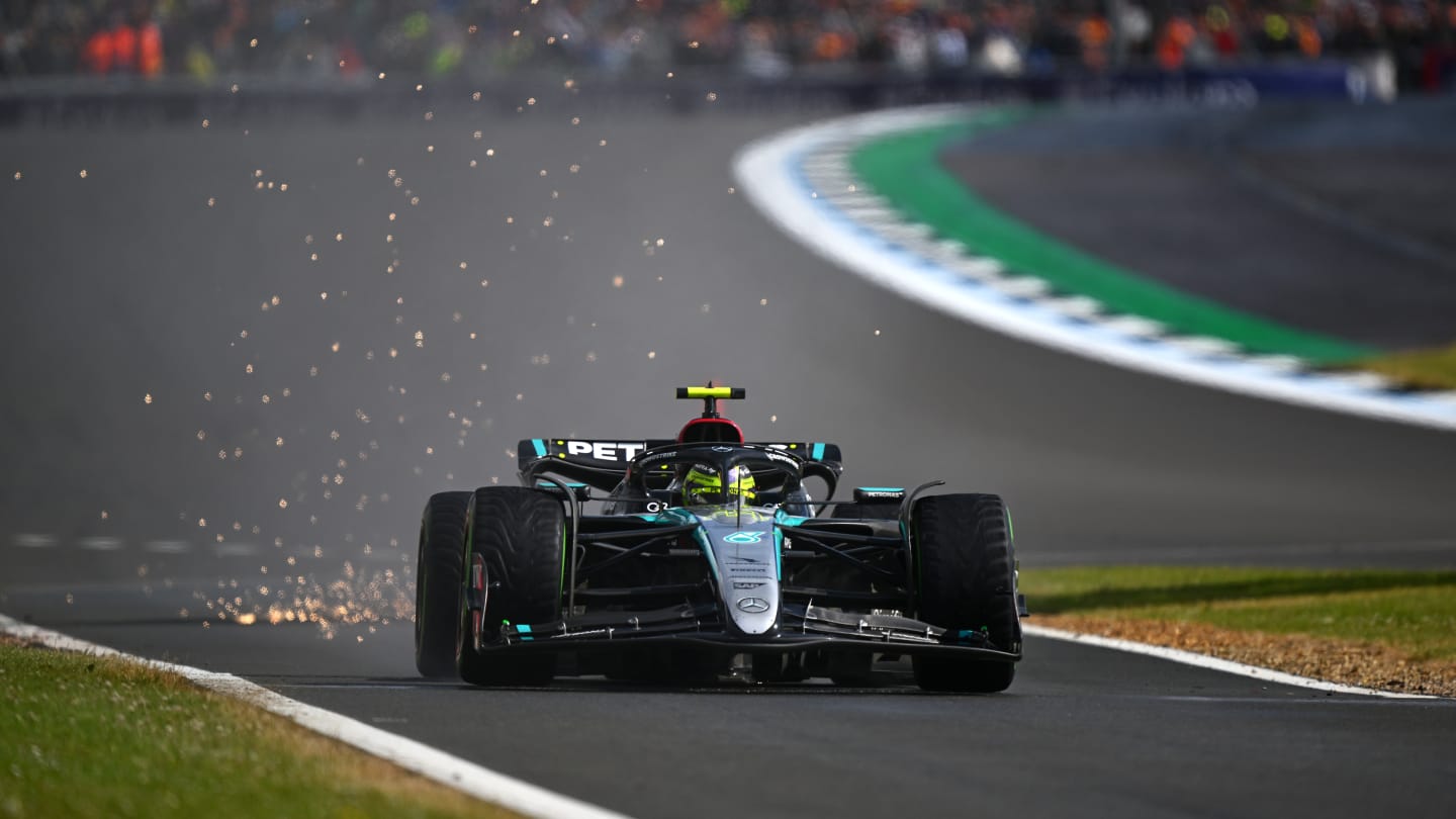 NORTHAMPTON, ENGLAND - JULY 07: Sparks fly behind Lewis Hamilton of Great Britain driving the (44)