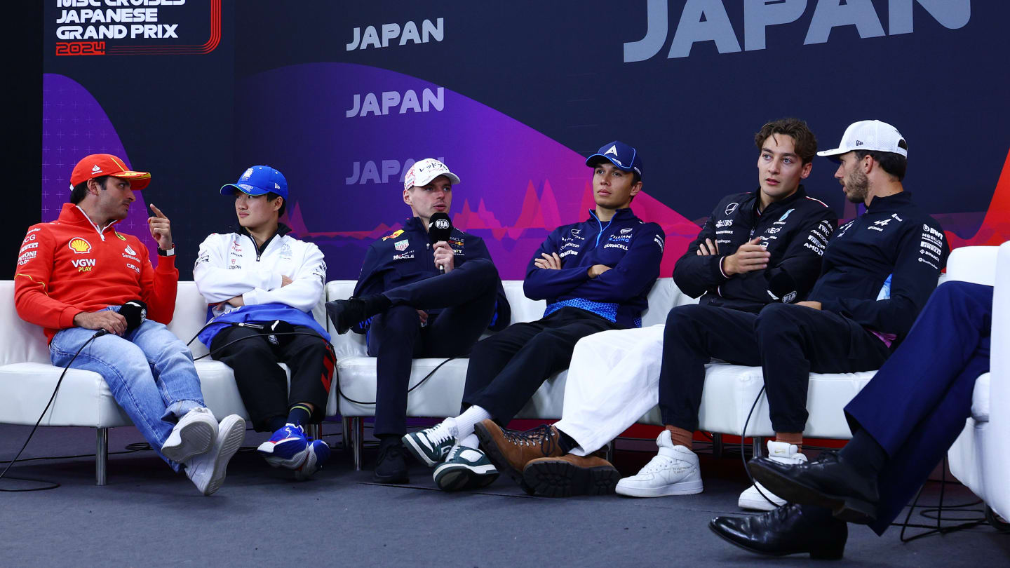 SUZUKA, JAPAN - APRIL 04: Carlos Sainz of Spain and Ferrari, Yuki Tsunoda of Japan and Visa Cash