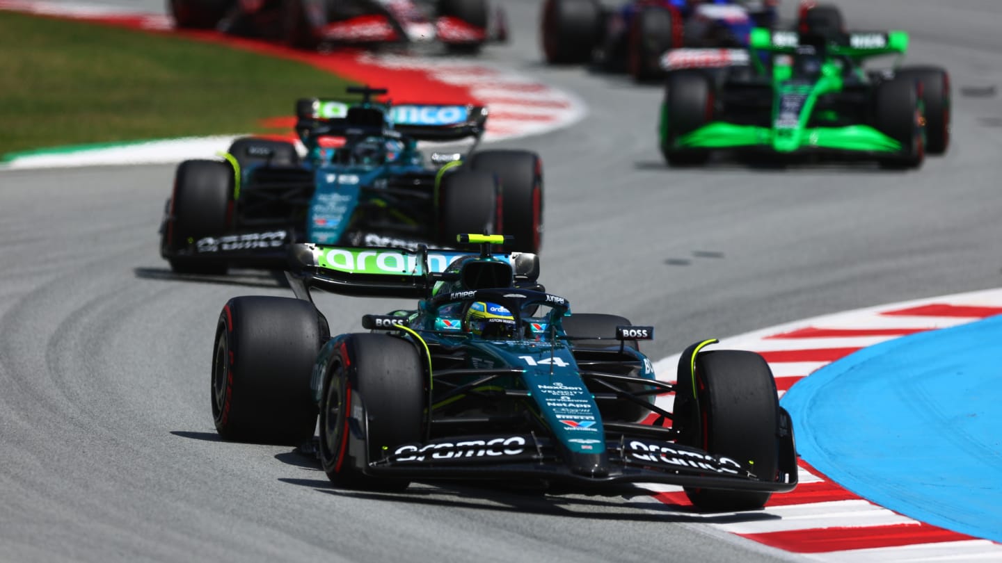 BARCELONA, SPAIN - JUNE 23: Fernando Alonso of Spain driving the (14) Aston Martin AMR24 Mercedes leads Lance Stroll of Canada driving the (18) Aston Martin AMR24 Mercedes during the F1 Grand Prix of Spain at Circuit de Barcelona-Catalunya on June 23, 2024 in Barcelona, Spain. (Photo by Clive Rose - Formula 1/Formula 1 via Getty Images)