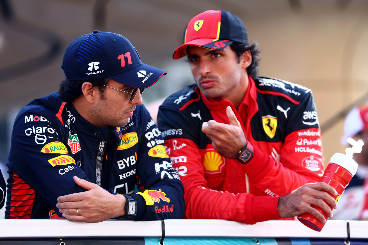 ABU DHABI, UNITED ARAB EMIRATES - NOVEMBER 26: Sergio Perez of Mexico and Oracle Red Bull Racing and Carlos Sainz of Spain and Ferrari talk on the drivers parade prior to the F1 Grand Prix of Abu Dhabi at Yas Marina Circuit on November 26, 2023 in Abu Dhabi, United Arab Emirates. (Photo by Clive Rose/Getty Images)
