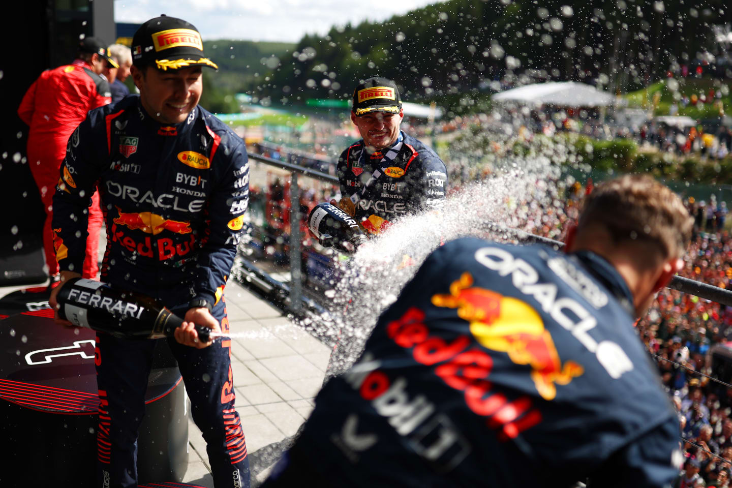 SPA, BELGIUM - JULY 30: Race winner Max Verstappen of the Netherlands and Oracle Red Bull Racing, Second placed Sergio Perez of Mexico and Oracle Red Bull Racing and Greg Reeson, Tyre Technician at Red Bull Racing celebrate on the podium during the F1 Grand Prix of Belgium at Circuit de Spa-Francorchamps on July 30, 2023 in Spa, Belgium. (Photo by Dan Istitene - Formula 1/Formula 1 via Getty Images)