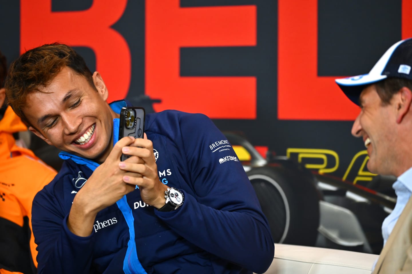 SPA, BELGIUM - JULY 27: Alexander Albon of Thailand and Williams takes a photo of Tom Clarkson wearing his hat in the Drivers Press Conference during previews ahead of the F1 Grand Prix of Belgium at Circuit de Spa-Francorchamps on July 27, 2023 in Spa, Belgium. (Photo by Dan Mullan/Getty Images)