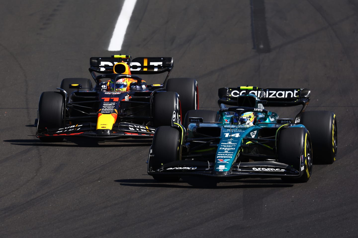BUDAPEST, HUNGARY - JULY 23: Fernando Alonso of Spain driving the (14) Aston Martin AMR23 Mercedes leads Sergio Perez of Mexico driving the (11) Oracle Red Bull Racing RB19 during the F1 Grand Prix of Hungary at Hungaroring on July 23, 2023 in Budapest, Hungary. (Photo by Mark Thompson/Getty Images)