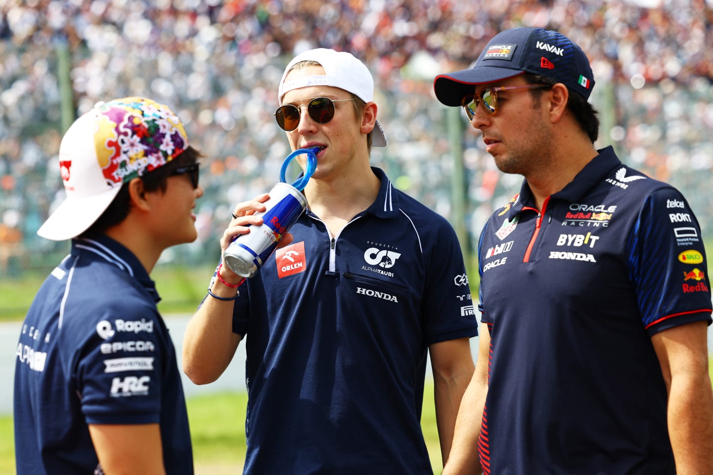 SUZUKA, JAPAN - SEPTEMBER 24: Liam Lawson of New Zealand and Scuderia AlphaTauri talks with Yuki Tsunoda of Japan and Scuderia AlphaTauri and Sergio Perez of Mexico and Oracle Red Bull Racing on the drivers parade prior to the F1 Grand Prix of Japan at Suzuka International Racing Course on September 24, 2023 in Suzuka, Japan. (Photo by Mark Thompson/Getty Images)