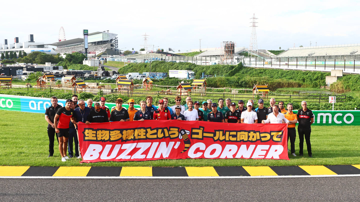 SUZUKA, JAPAN - SEPTEMBER 21: The F1 community pose for a photo with Sebastian Vettel to launch the