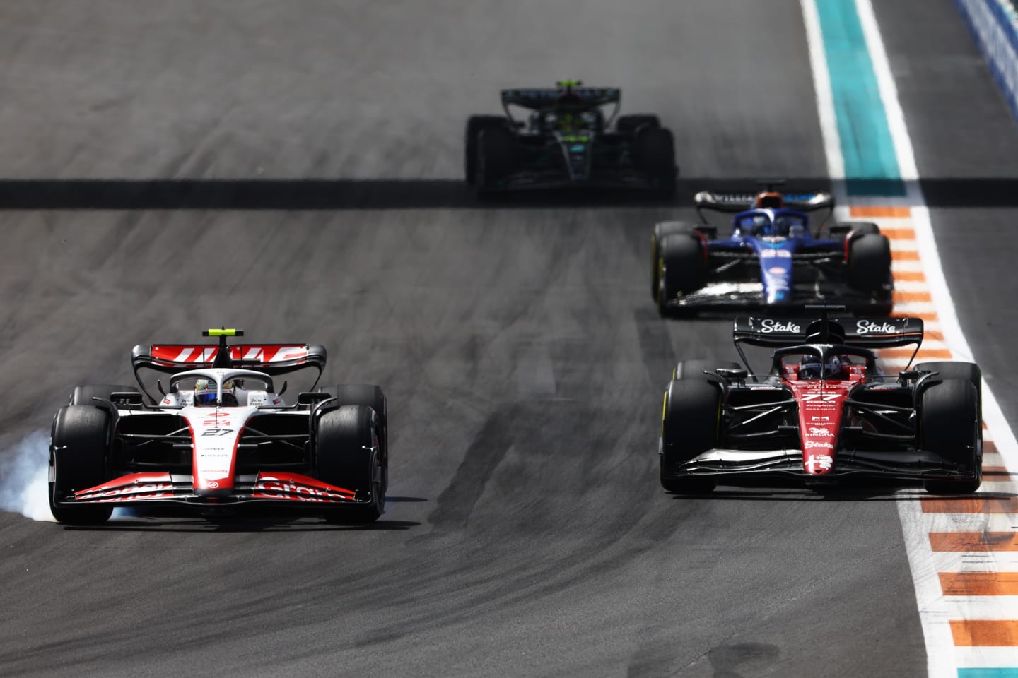 MIAMI, FLORIDA - MAY 07: Nico Hulkenberg of Germany driving the (27) Haas F1 VF-23 Ferrari locks a wheel under braking as he overtakes Valtteri Bottas of Finland driving the (77) Alfa Romeo F1 C43 Ferrari during the F1 Grand Prix of Miami at Miami International Autodrome on May 07, 2023 in Miami, Florida. (Photo by Mark Thompson/Getty Images)