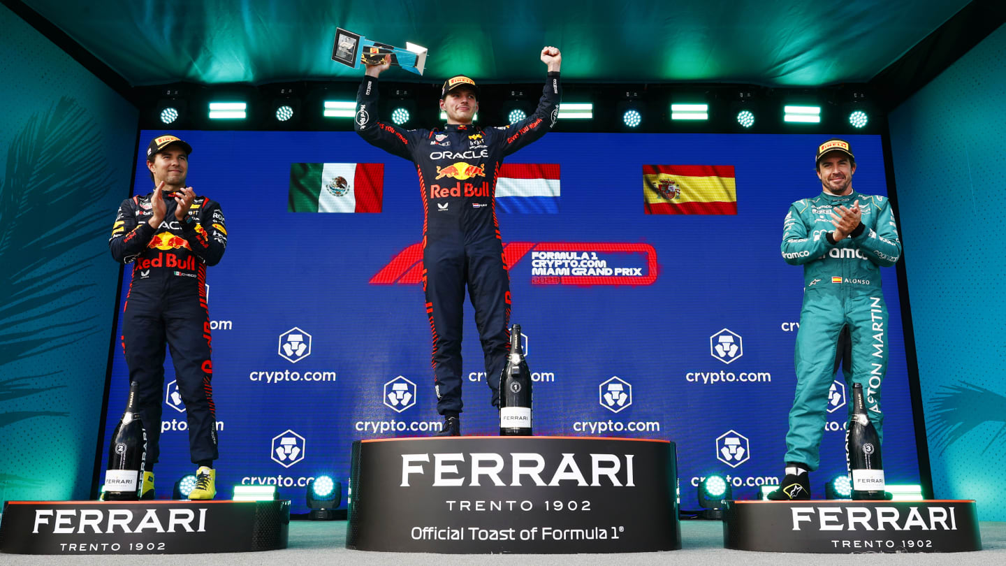 MIAMI, FLORIDA - MAY 07: Race winner Max Verstappen of the Netherlands and Oracle Red Bull Racing (C) celebrates on the podium between Second placed Sergio Perez of Mexico and Oracle Red Bull Racing (L) and Third placed Fernando Alonso of Spain and Aston Martin F1 Team (R) during the F1 Grand Prix of Miami at Miami International Autodrome on May 07, 2023 in Miami, Florida. (Photo by Dan Istitene - Formula 1/Formula 1 via Getty Images)