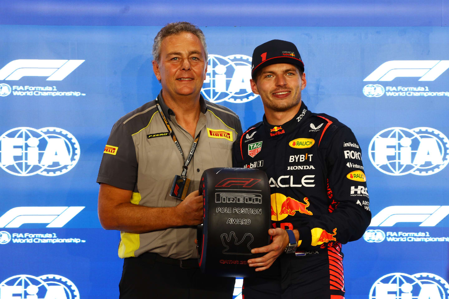 LUSAIL CITY, QATAR - OCTOBER 06: Pole position qualifier Max Verstappen of the Netherlands and Oracle Red Bull Racing is presented with the Pirelli Pole Position Trophy by Director of Pirelli F1 Mario Isola during qualifying ahead of the F1 Grand Prix of Qatar at Lusail International Circuit on October 06, 2023 in Lusail City, Qatar. (Photo by Mark Thompson/Getty Images)