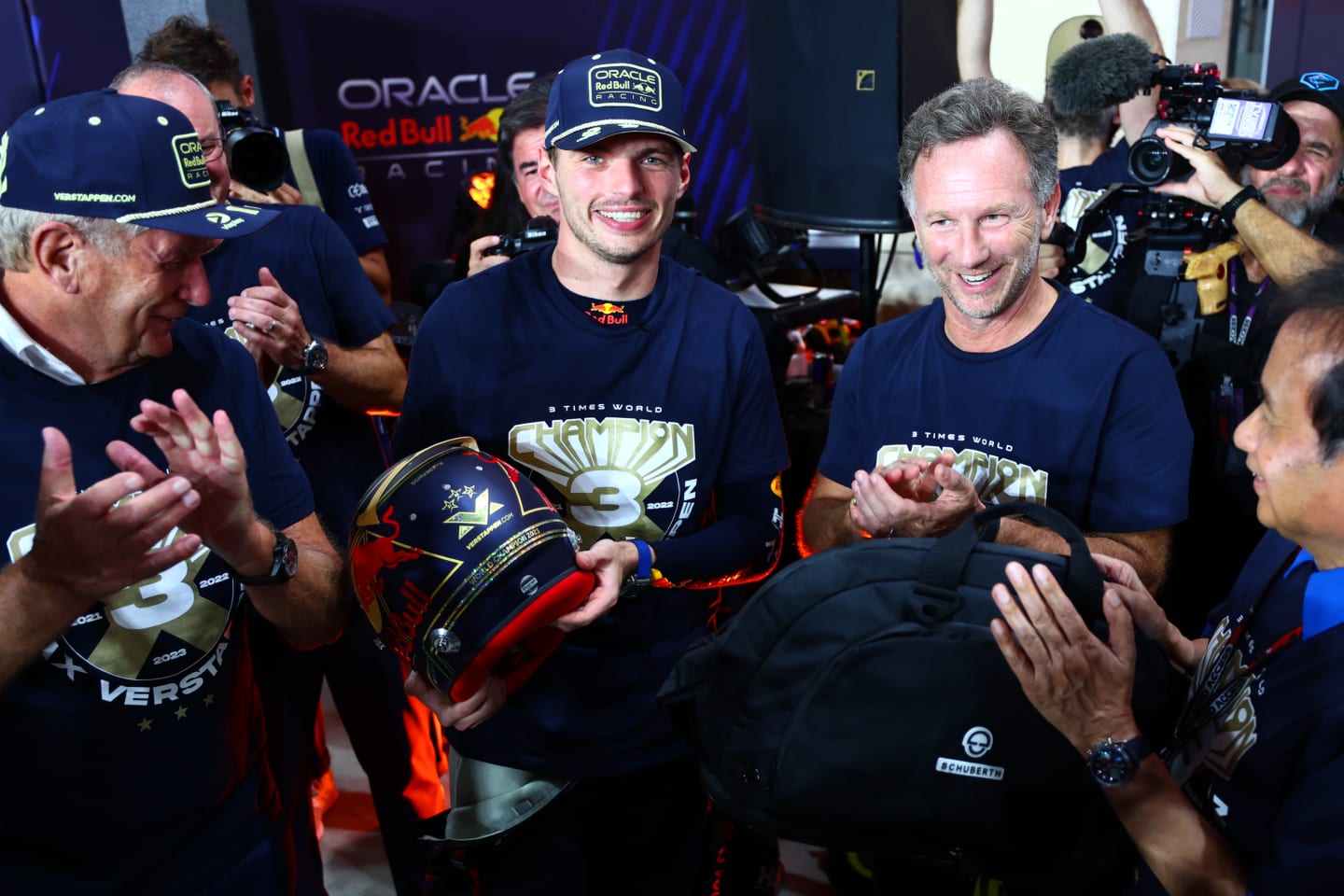 LUSAIL CITY, QATAR - OCTOBER 07: 2023 F1 World Drivers Champion Max Verstappen of the Netherlands and Oracle Red Bull Racing is congratulted by Red Bull Racing Team Principal Christian Horner , Chalerm Yoovidhya and Red Bull Racing Team Consultant Dr Helmut Marko as he is presented with a celebratory helmet after the sprint race ahead of the F1 Grand Prix of Qatar at Lusail International Circuit on October 07, 2023 in Lusail City, Qatar. (Photo by Dan Istitene - Formula 1/Formula 1 via Getty Images)