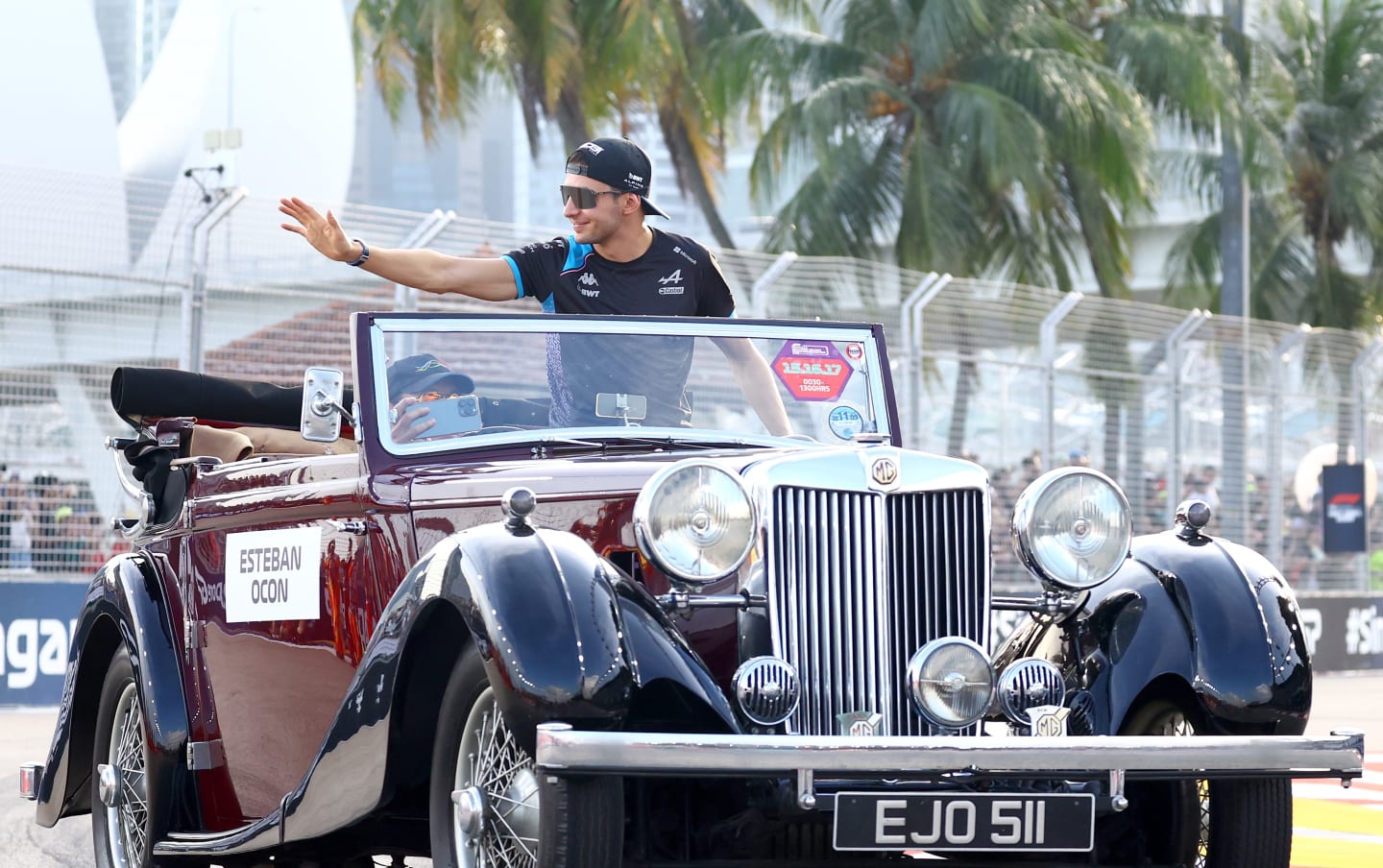 SINGAPORE, SINGAPORE - SEPTEMBER 17: Esteban Ocon of France and Alpine F1 waves to the crowd on the drivers parade prior to the F1 Grand Prix of Singapore at Marina Bay Street Circuit on September 17, 2023 in Singapore, Singapore. (Photo by Mark Thompson/Getty Images)