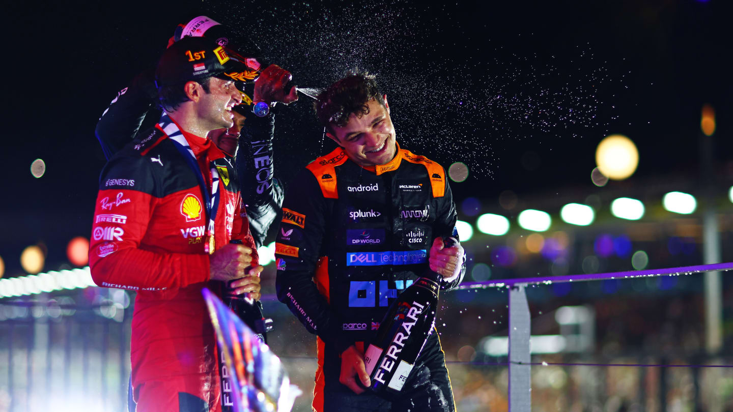 SINGAPORE, SINGAPORE - SEPTEMBER 17: Race winner Carlos Sainz of Spain and Ferrari celebrates with Second placed Lando Norris of Great Britain and McLaren and third placed Lewis Hamilton of Great Britain and Mercedes on the podium during the F1 Grand Prix of Singapore at Marina Bay Street Circuit on September 17, 2023 in Singapore, Singapore. (Photo by Dan Istitene - Formula 1/Formula 1 via Getty Images)