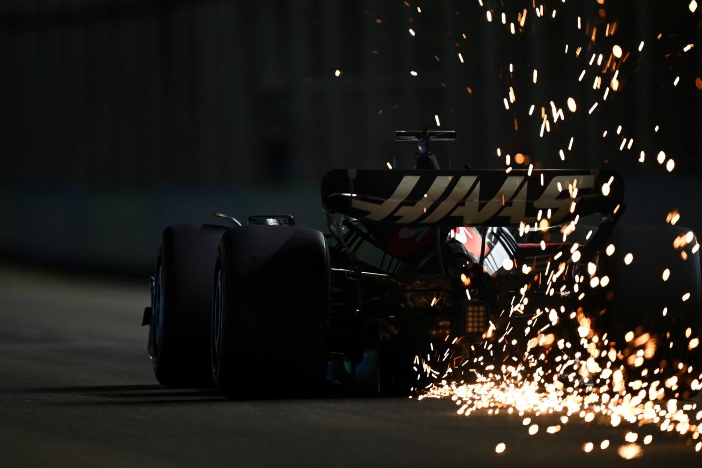 SINGAPORE, SINGAPORE - SEPTEMBER 16: Sparks fly from the car of Kevin Magnussen of Denmark driving the (20) Haas F1 VF-23 Ferrari during qualifying ahead of the F1 Grand Prix of Singapore at Marina Bay Street Circuit on September 16, 2023 in Singapore, Singapore. (Photo by Clive Mason/Getty Images)