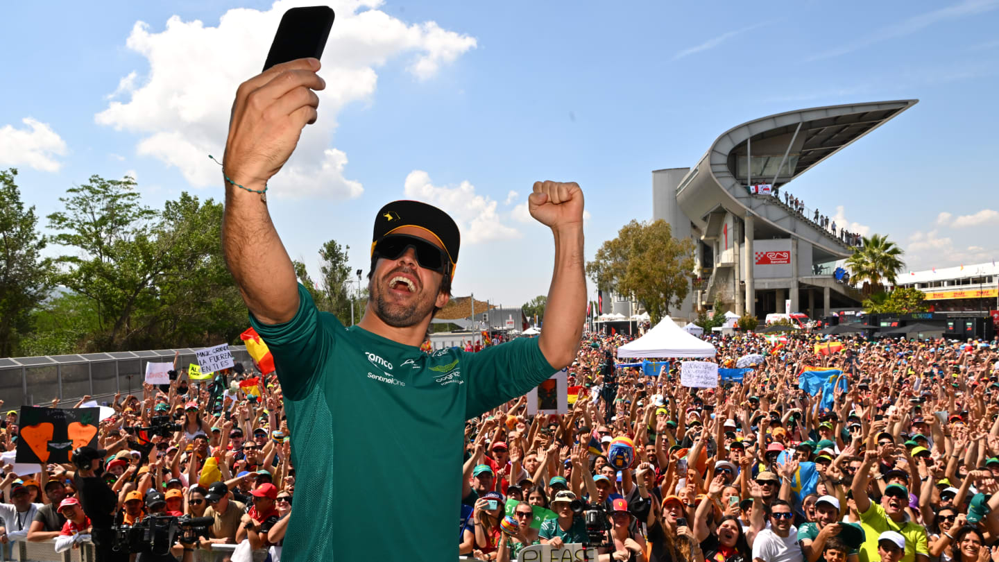 BARCELONA, SPAIN - JUNE 02: Fernando Alonso of Spain and Aston Martin F1 Team takes a photo from the fan stage prior to practice ahead of the F1 Grand Prix of Spain at Circuit de Barcelona-Catalunya on June 02, 2023 in Barcelona, Spain. (Photo by Dan Mullan - Formula 1/Formula 1 via Getty Images)