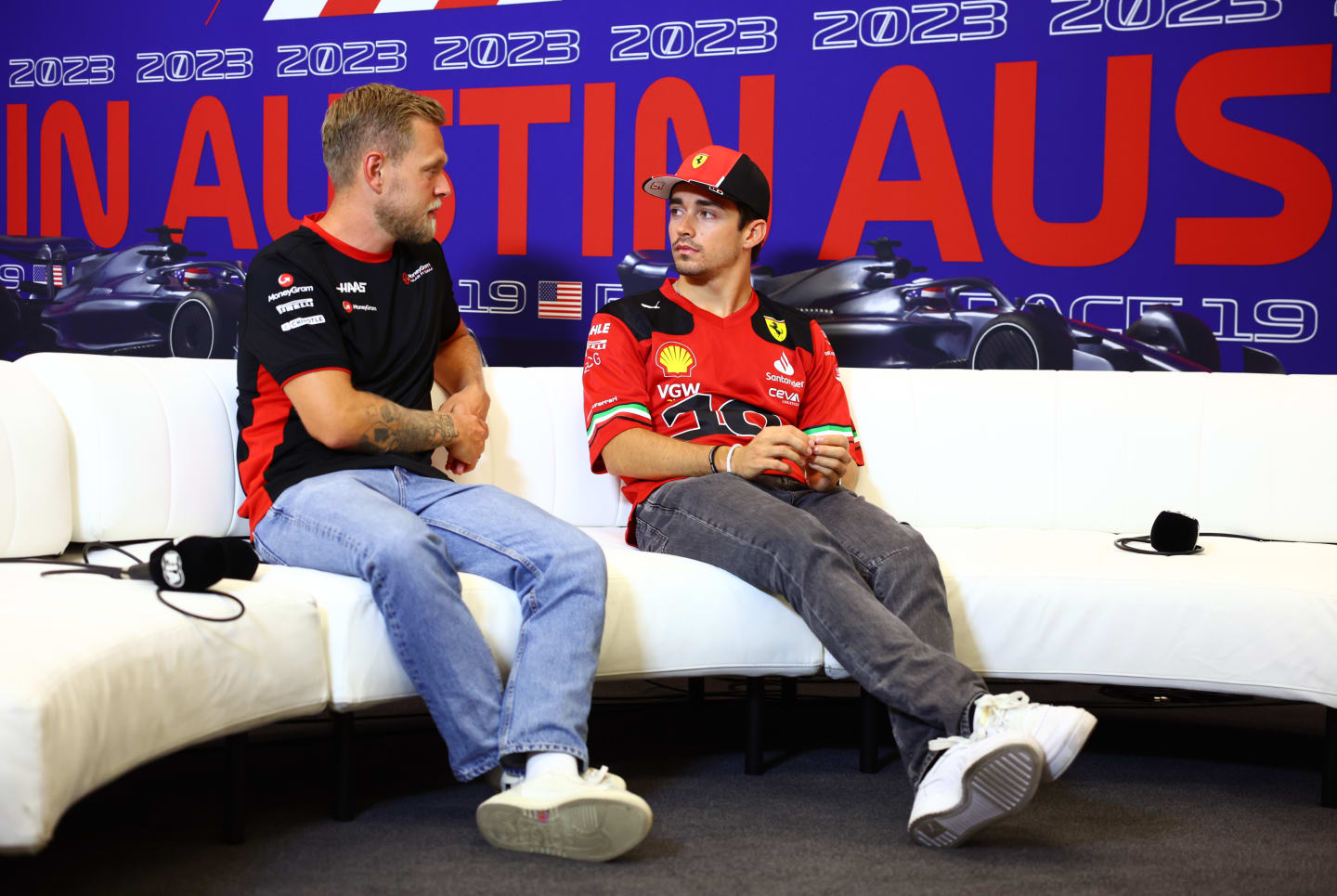 AUSTIN, TEXAS - OCTOBER 19: Kevin Magnussen of Denmark and Haas F1 and Charles Leclerc of Monaco and Ferrari talk in the Drivers Press Conference during previews ahead of the F1 Grand Prix of United States at Circuit of The Americas on October 19, 2023 in Austin, Texas. (Photo by Dan Istitene/Getty Images)