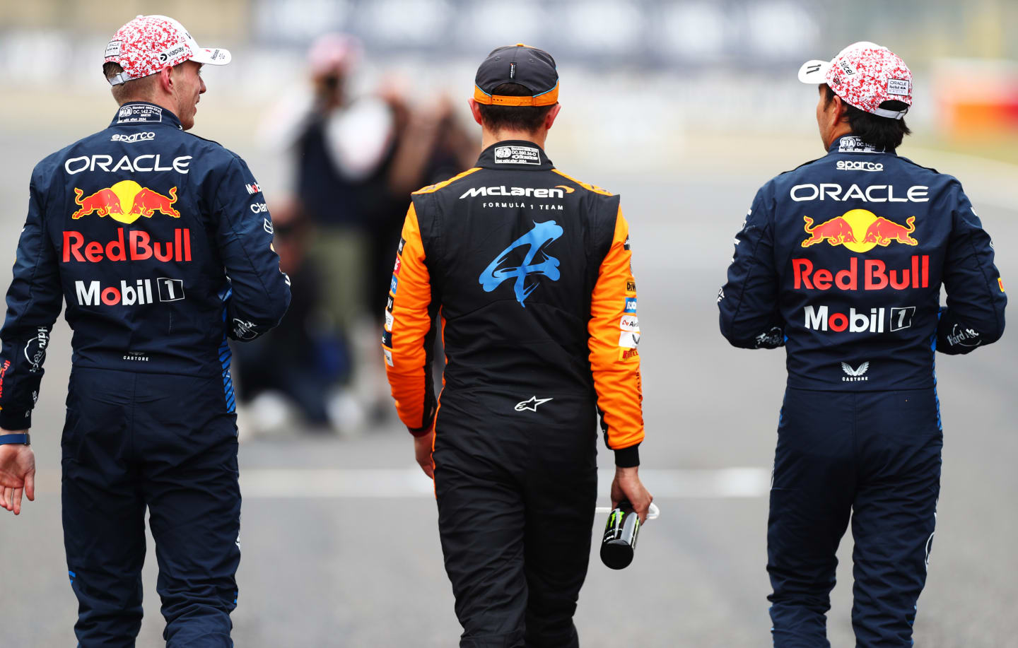 SUZUKA, JAPAN - APRIL 06: Race winner qualifier Max Verstappen of the Netherlands and Oracle Red Bull Racing (L), Second placed qualifier Sergio Perez of Mexico and Oracle Red Bull Racing (R) and Third placed qualifier Lando Norris of Great Britain and McLaren (C) walk in parc ferme during qualifying ahead of the F1 Grand Prix of Japan at Suzuka International Racing Course on April 06, 2024 in Suzuka, Japan. (Photo by Peter Fox/Getty Images)