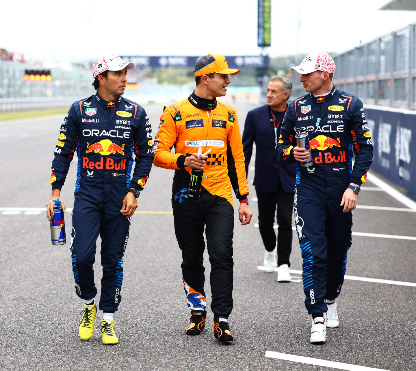 SUZUKA, JAPAN - APRIL 06: Pole position qualifier Max Verstappen of the Netherlands and Oracle Red Bull Racing (R), Second placed qualifier Sergio Perez of Mexico and Oracle Red Bull Racing (L) and Third placed qualifier Lando Norris of Great Britain and McLaren (C) walk in parc ferme during qualifying ahead of the F1 Grand Prix of Japan at Suzuka International Racing Course on April 06, 2024 in Suzuka, Japan. (Photo by Mark Thompson/Getty Images)