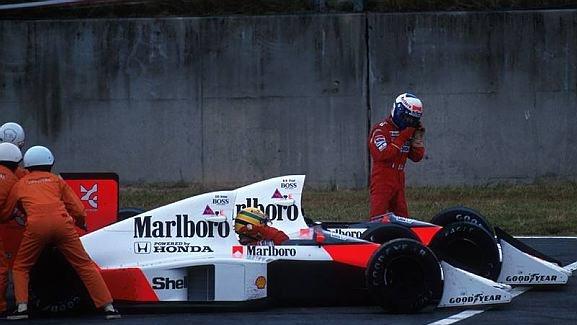 Alain Prost (FRA) McLaren MP4/5 walks from his car following a collision with team mate Ayrton Senna (BRA) at the entrance to the chicane. Meanwhile Senna pleads with the marshals to push start him. They did, he recovered to win, but was disqualified. Formula One World Championship, Japanese Grand Prix, Suzuka, Japan. 22 October 1989. © Sutton Images