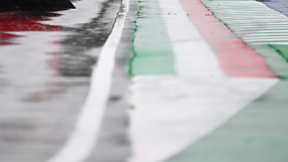 IMOLA, ITALY - APRIL 22: A track marshal clears rain water from the circuit during the delayed