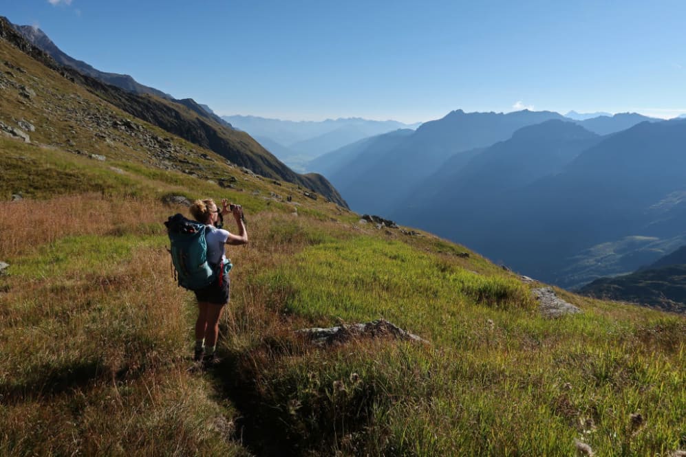 NEUSTIFT IM STUBAITAL, AUSTRIA - 25 DE AGOSTO: Un excursionista alpino toma una foto con su teléfono inteligente junto