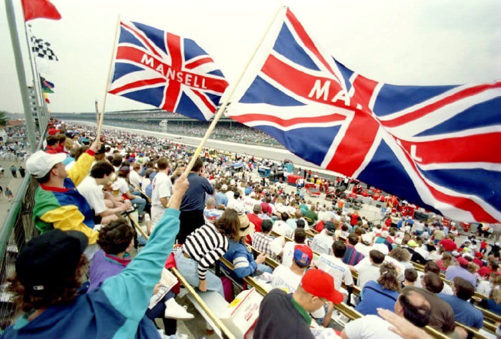 Fans of British driver Nigel Mansell wave the Union Jack as he speeds down the main straghtaway 14