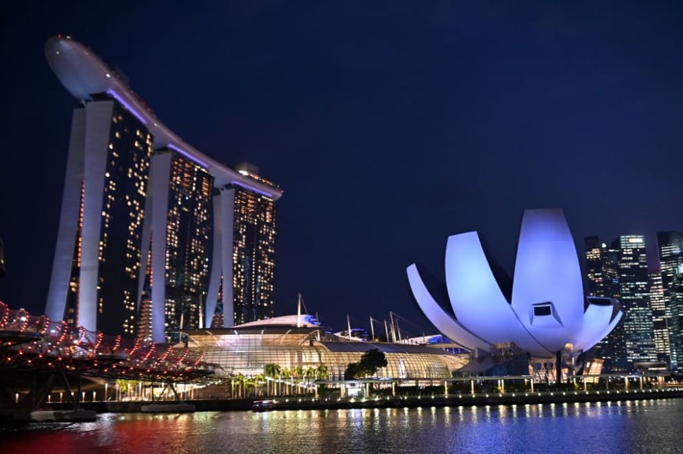The Marina Bay Sands hotel and resorts (L) and the ArtScience Museum (R) are illuminated under the