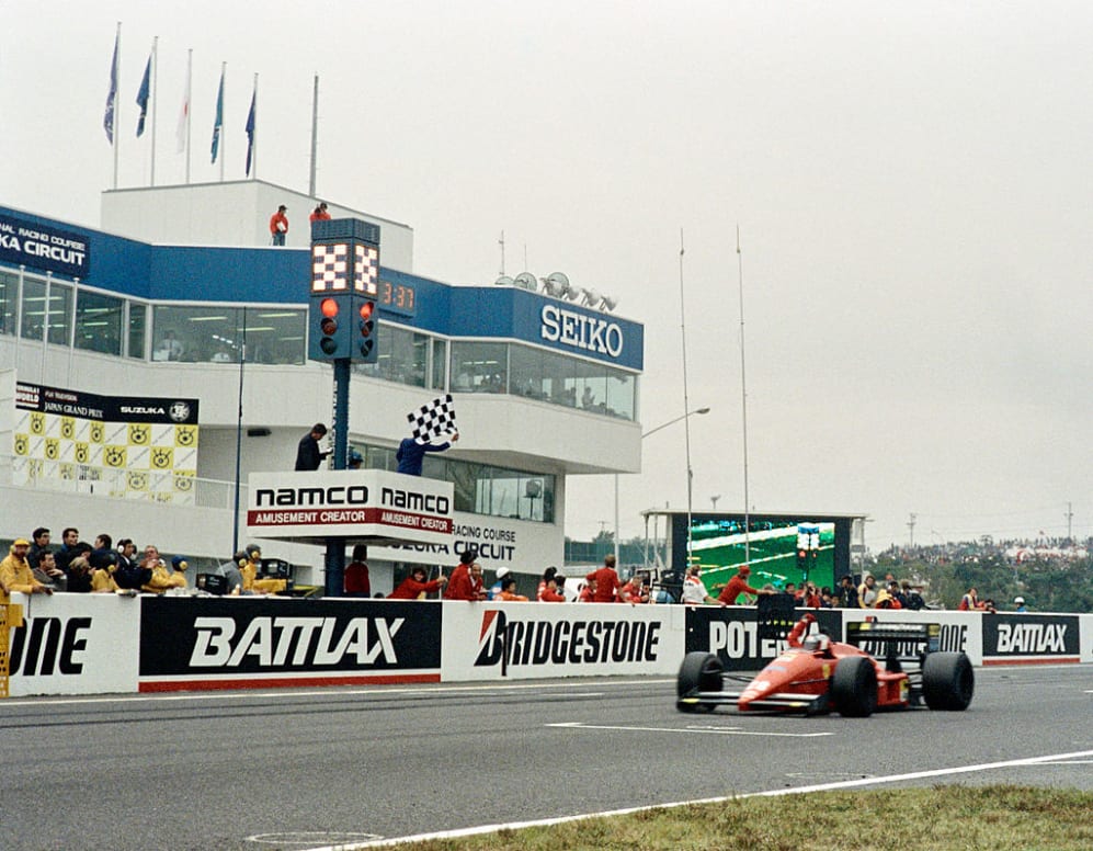Austrian Ferrari driver Gerhard Berger raises his hand as he crosses the finish line to win the