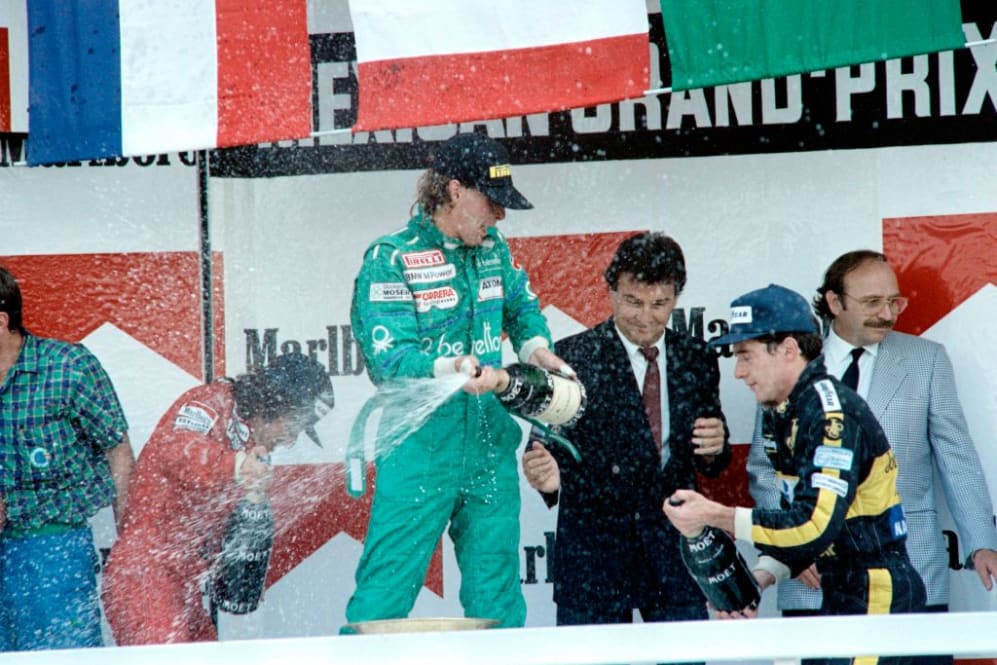 Austrian pilot Gerhard Berger (C) sprinkles with champagne on October 12, 1986 French Alain Prost