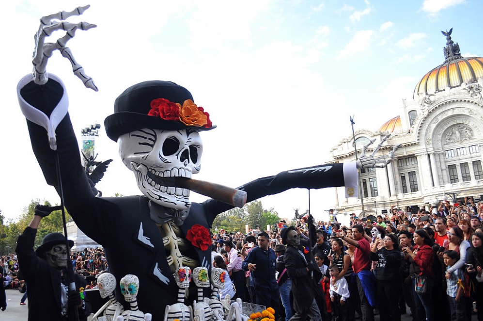 Floats depicting "Catrinas" and other death related characters and offerings march during the first