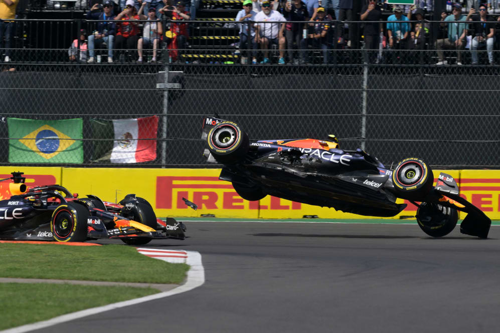 TOPSHOT - El piloto mexicano de Red Bull Racing, Sergio Pérez (R), se estrella durante el inicio de la Fórmula