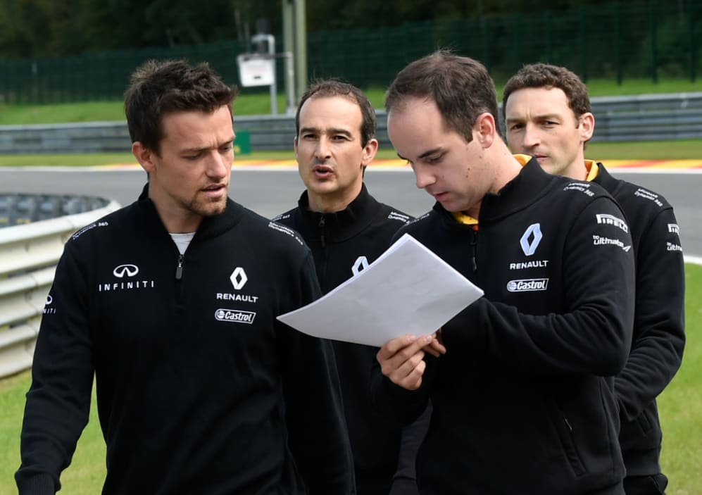 Renault Sport F1 Team's British driver Jolyon Palmer (L) speaks with team staff as he walks in the