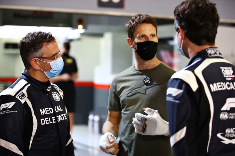BAHRAIN, BAHRAIN - DECEMBER 03: Romain Grosjean of France and Haas F1 talks with FIA Medical Car